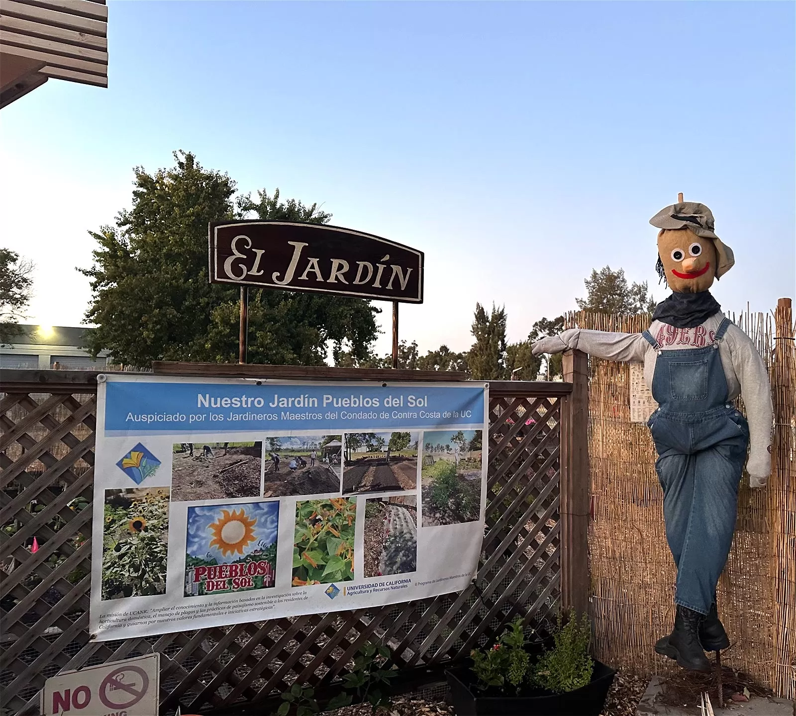 Pueblos Del Sol Garden (El Jardín) with a smiling scarecrow wearing a 49ers long sleeve t shirt