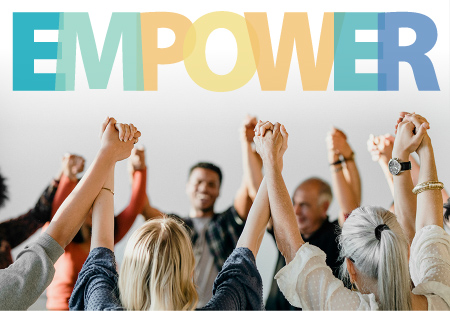 Group of people in a circle, holding hands with their hands in the air